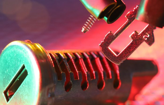 Macro shot of a mechanical lock cylinder and key, highlighting detailed components under vibrant lighting.