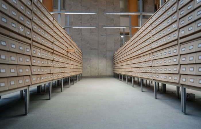 Spacious modern library archive with rows of wooden drawers for document storage.