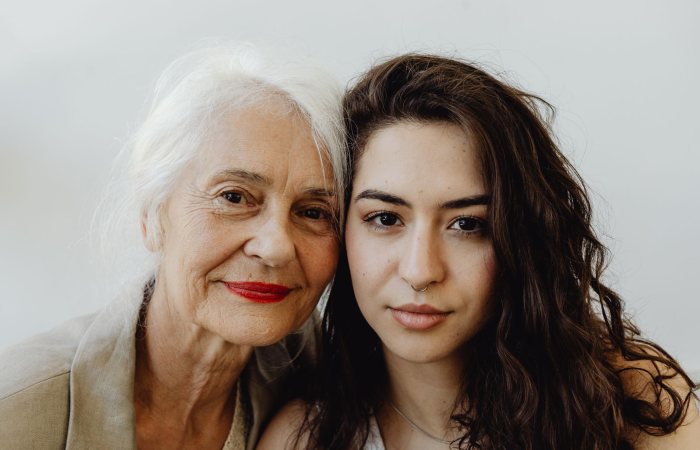 Elegant portrait of a grandmother and granddaughter looking directly at the camera, capturing their bond.