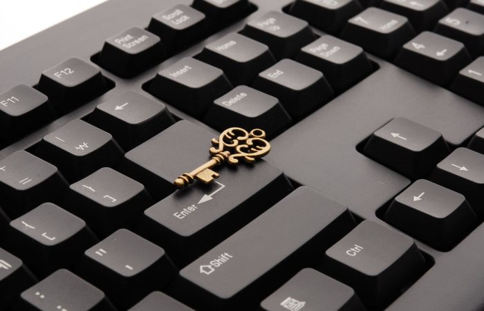 Close-up of an ornate vintage key placed on a modern computer keyboard.