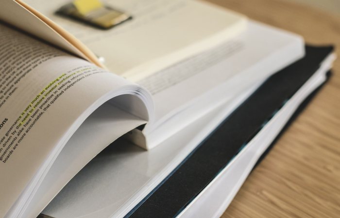 A pile of open books on a table, ideal for study and research themes.